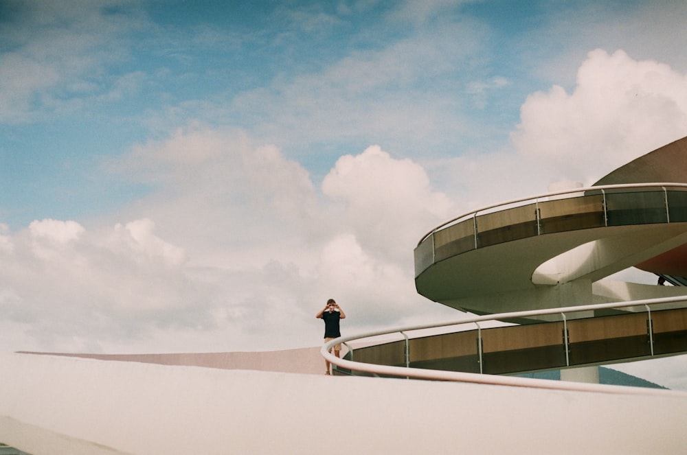 a person standing on a ledge in front of a building