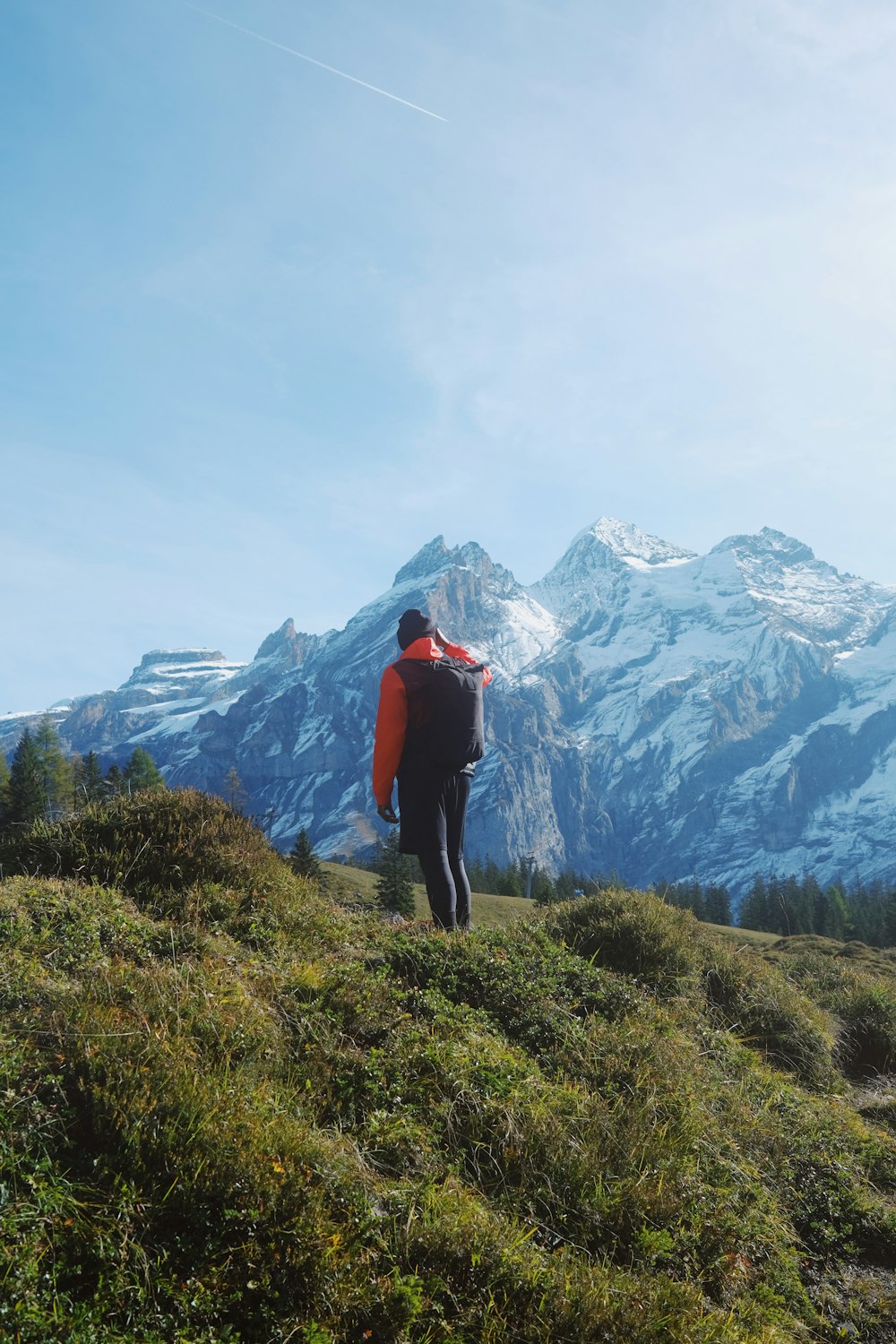 a man walking up a hill with a backpack