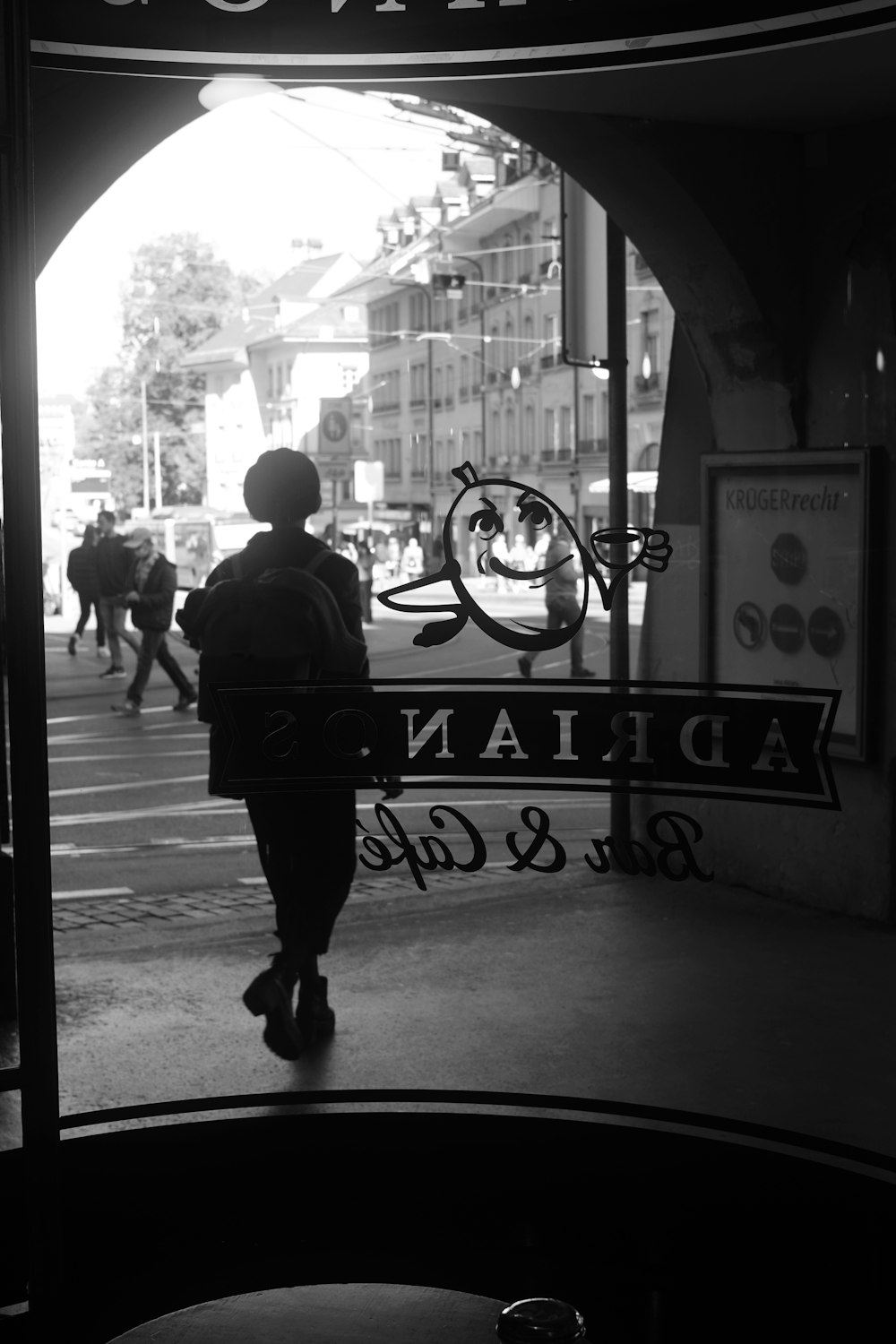 a person walking down a street past a sign