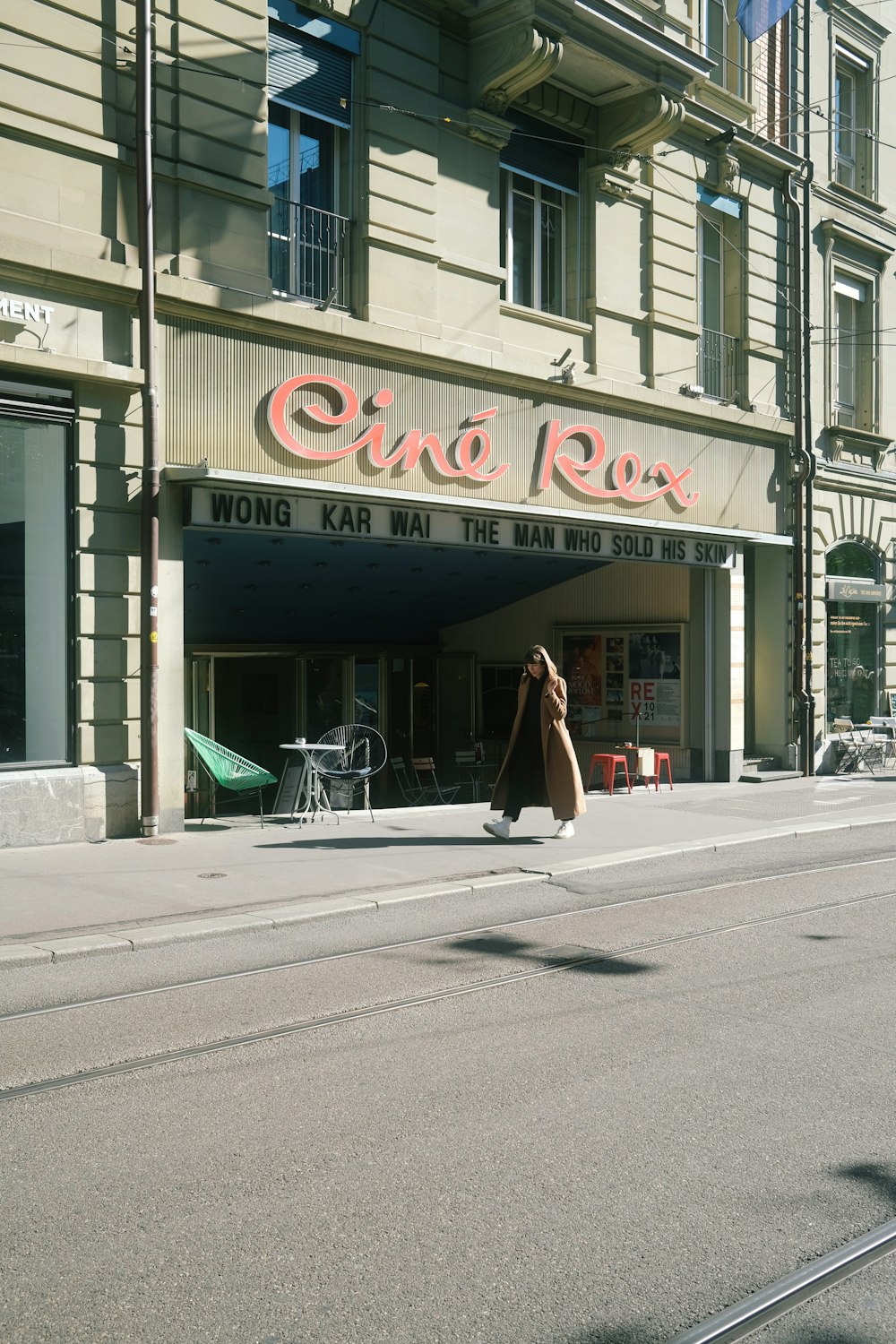 Une femme marchant dans une rue devant un grand immeuble