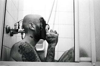 a man with a gun in his hand in front of a mirror