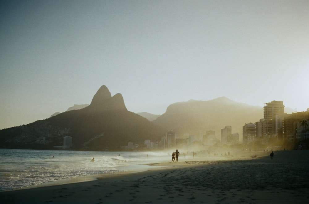 a couple of people are walking on the beach