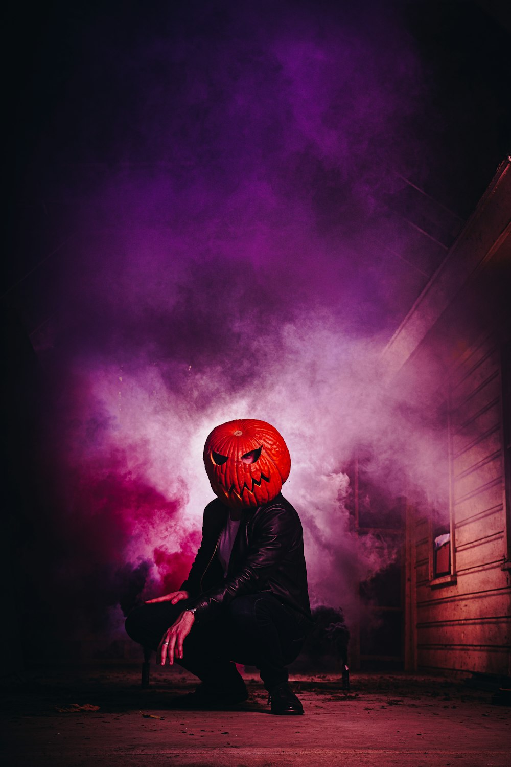 a person wearing a red pumpkin mask sitting on a bench