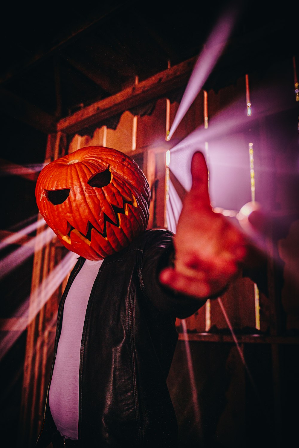 a man in a leather jacket wearing a pumpkin mask