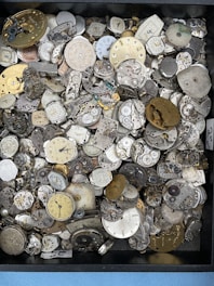 A selection of vintage watch parts and tools laid out on a wooden workbench.