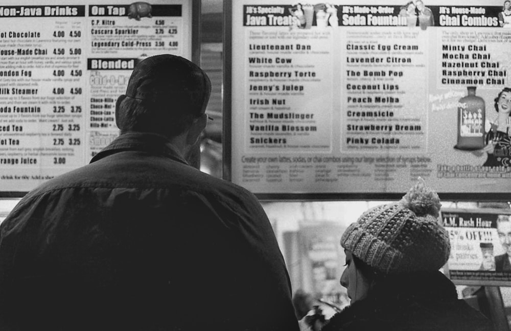 a man and a woman standing in front of a menu