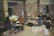A group of musicians are gathered in a rehearsal space. There are five people with various musical instruments, including a drum set, keyboard, and guitars. The room seems industrial, with exposed beams and scattered equipment. The atmosphere is casual, with some musicians seated on makeshift seating like pallets and cushions.