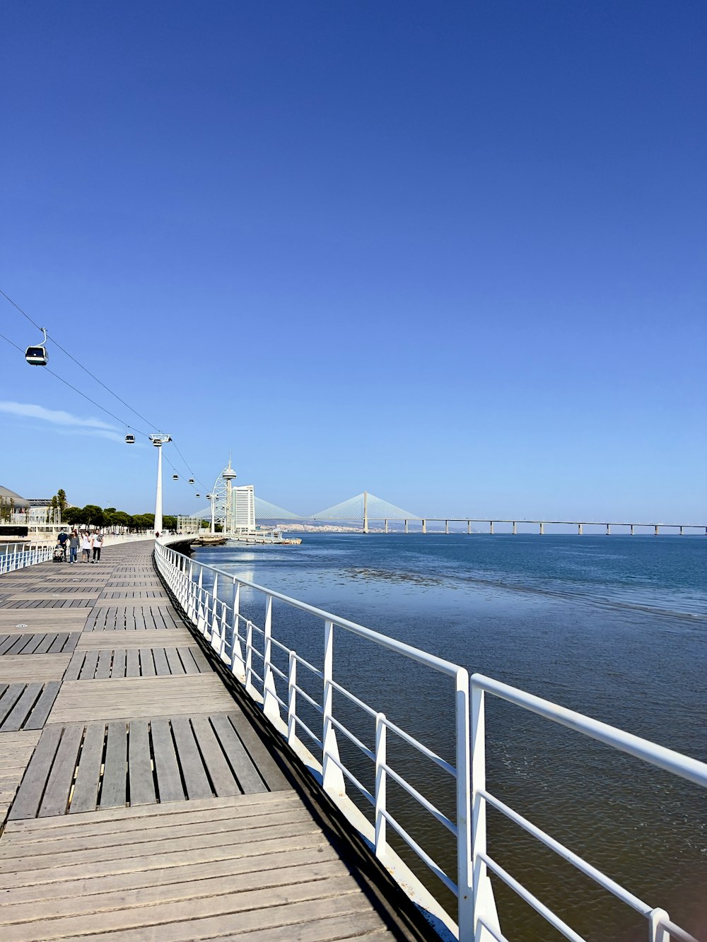 a long wooden pier next to a body of water