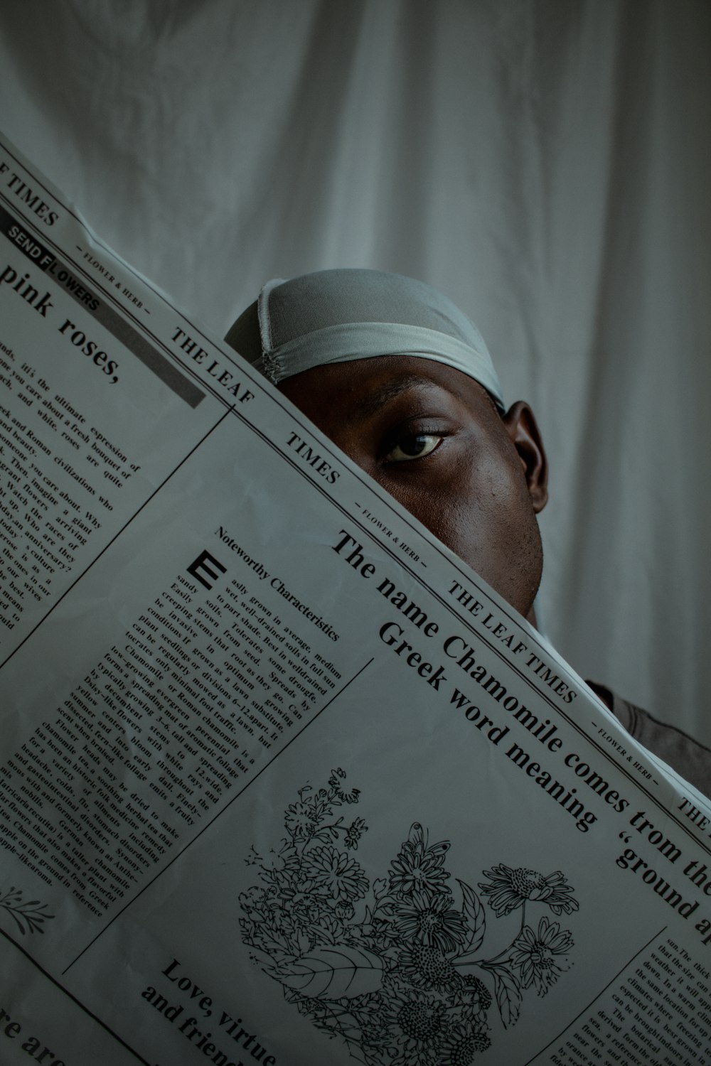 a man reading a newspaper while wearing a head band