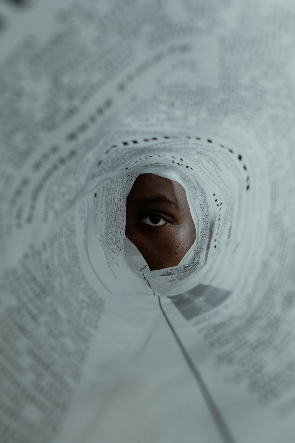 a person with a sheet of paper covering their face