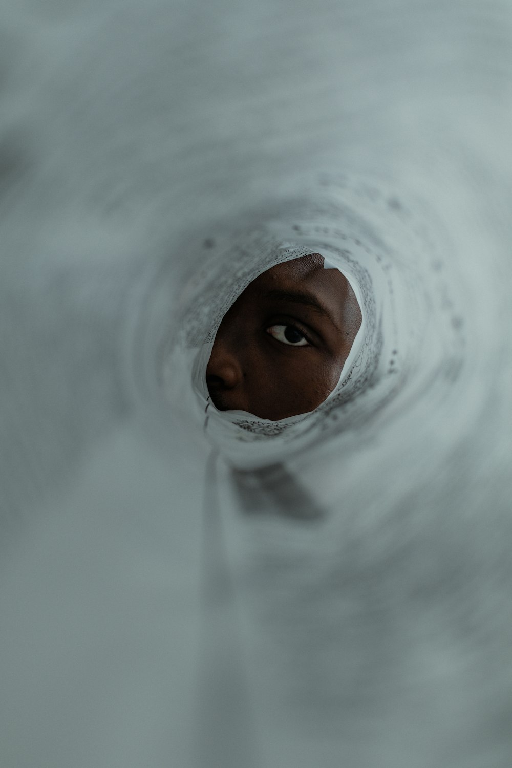 a woman's face is seen through a hole in the water