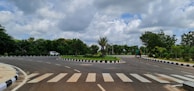 A red Littlebird Driving School car navigating a roundabout with clear instructor signals.