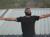 A satisfied customer standing in front of their newly roofed home.