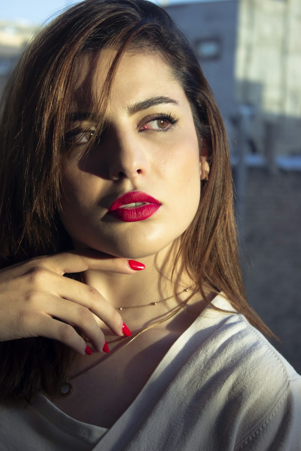 a woman with red nails and a white shirt