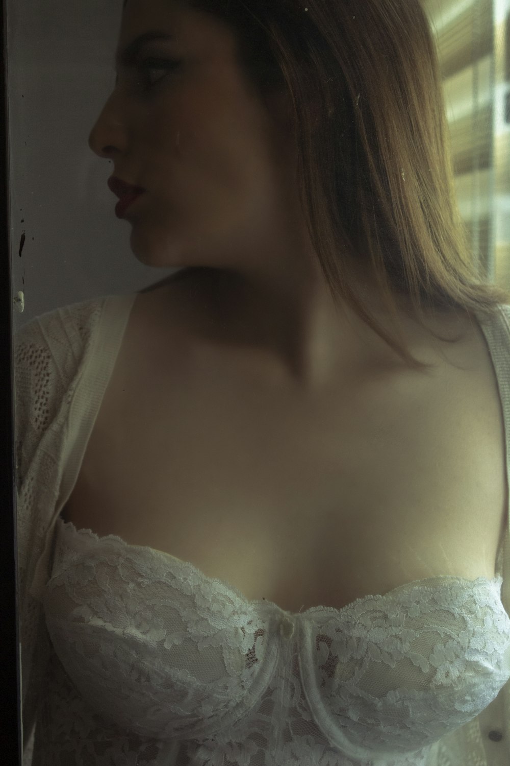 a woman in a white bra looking in a mirror