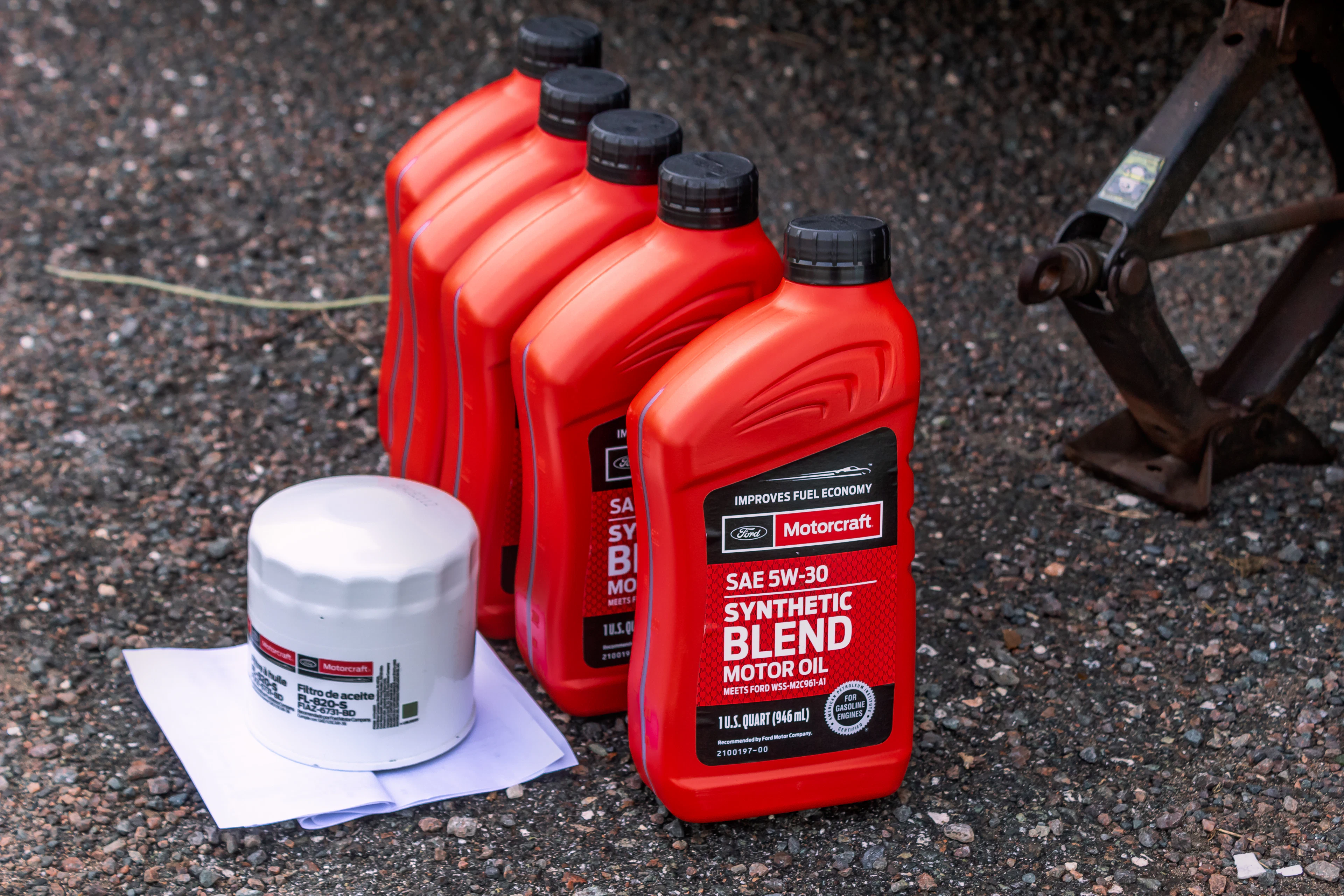 Bottles of motor oil next to a new oil filter