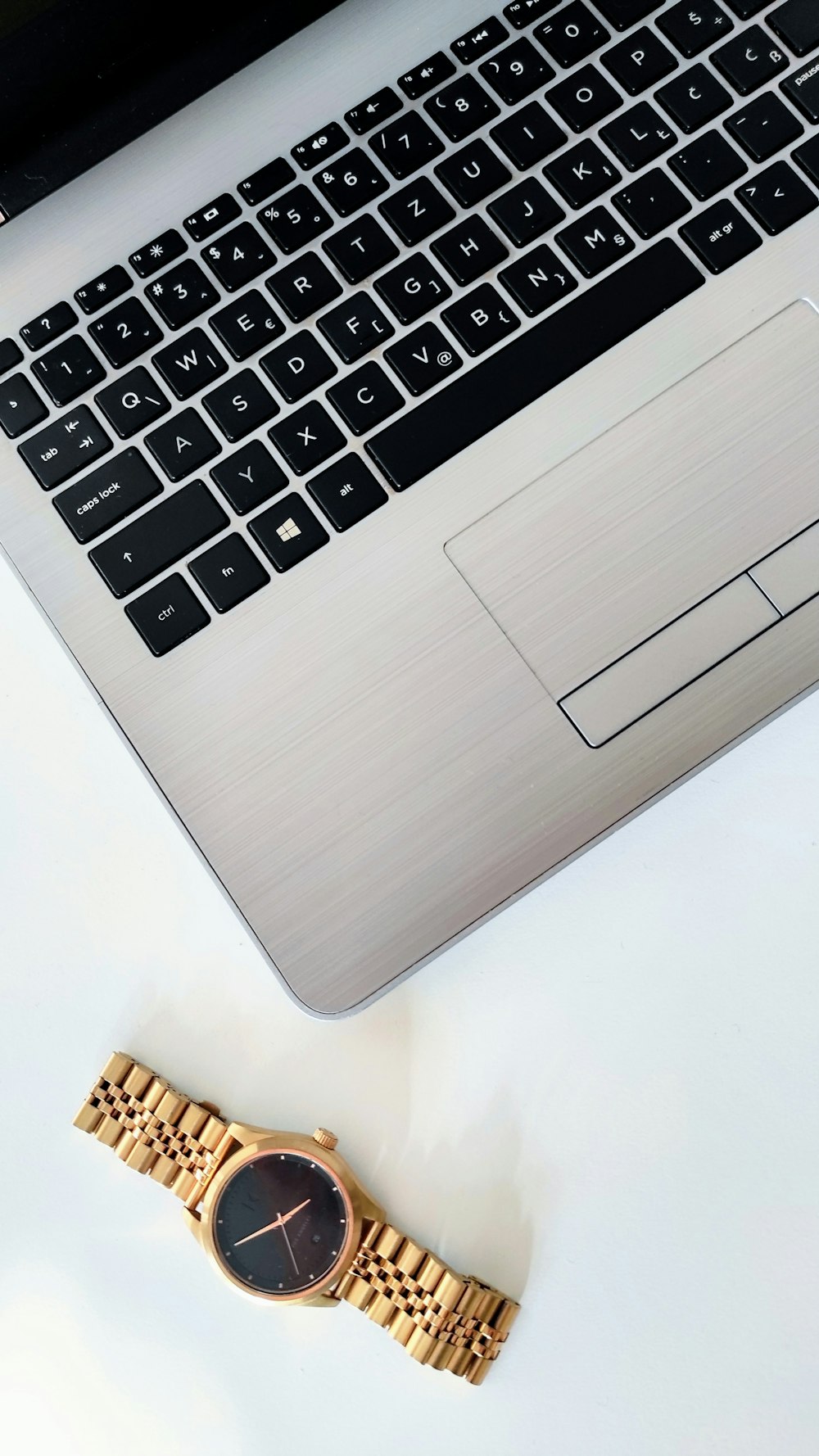 a watch sitting next to a laptop computer