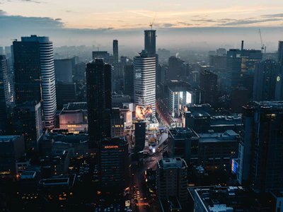 A modern cityscape at dusk with digital AI data overlays in the sky