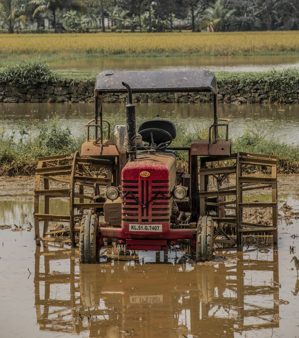 an old tractor is sitting in a muddy field
