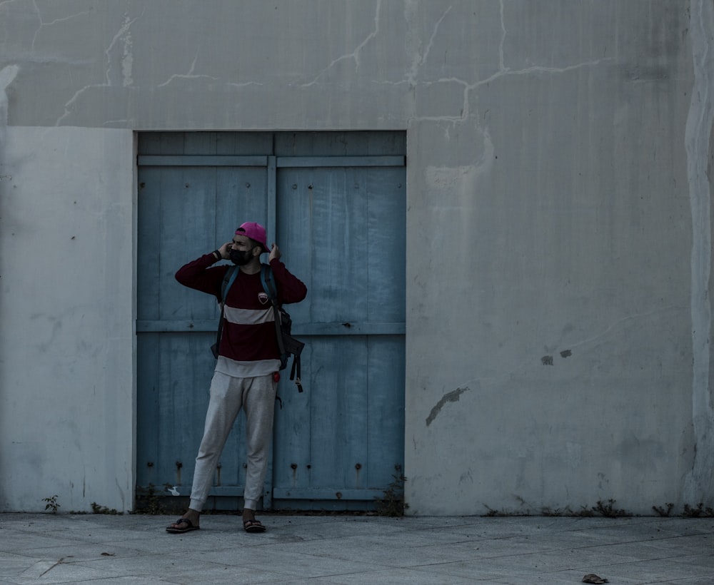 a man standing in front of a door talking on a cell phone