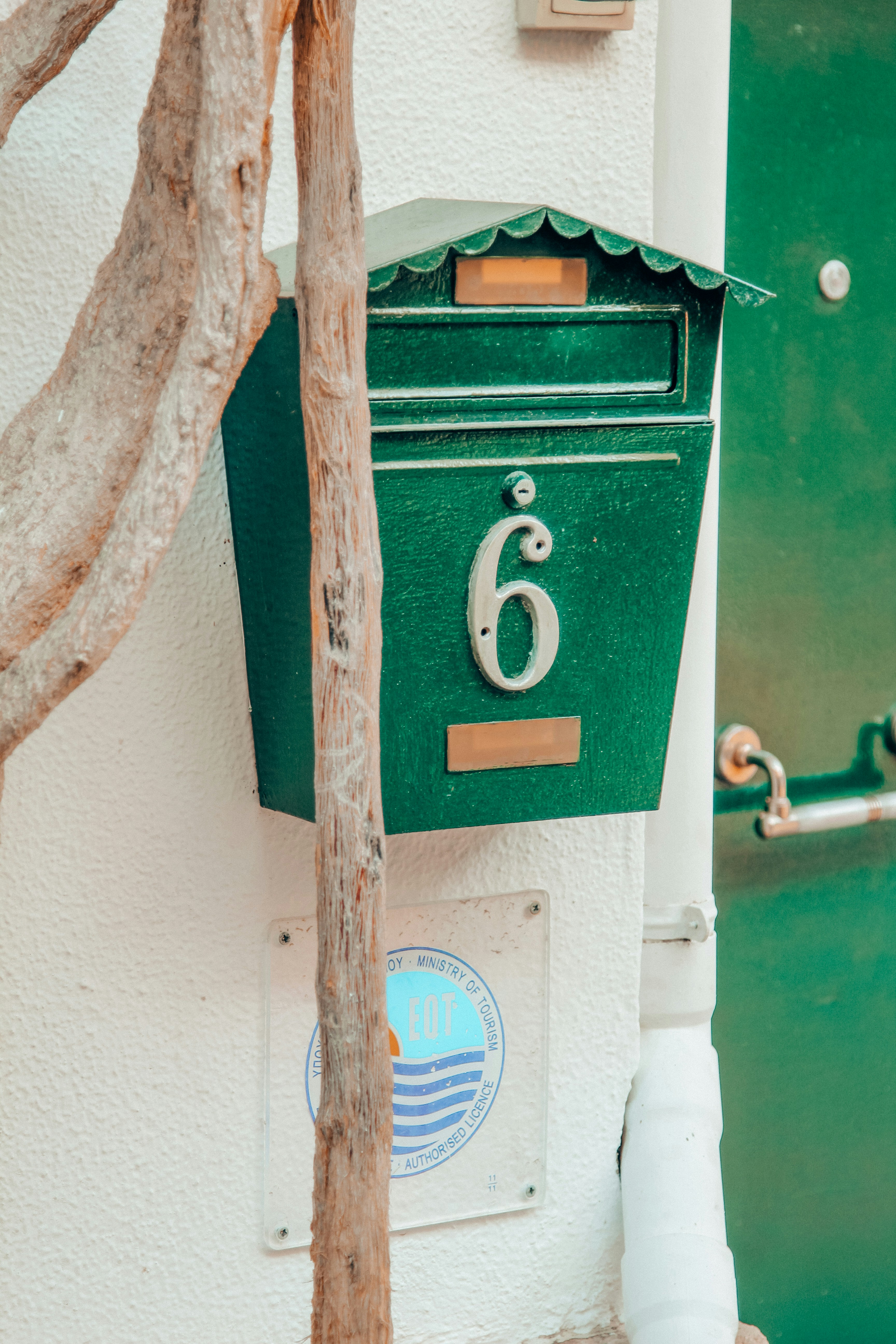A close up of a green mailbox on a wall photo Free Parga Image on Unsplash