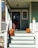 A beautifully decorated porch featuring an array of colorful pumpkins in various sizes, surrounded by autumn leaves and cozy decor.
