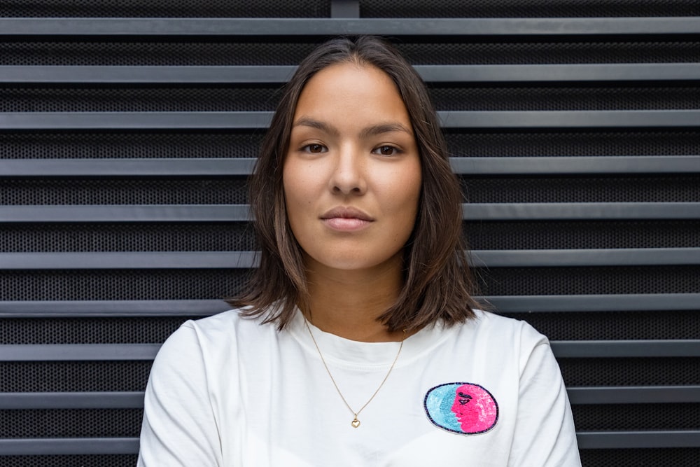 a woman in a white shirt is posing for a picture