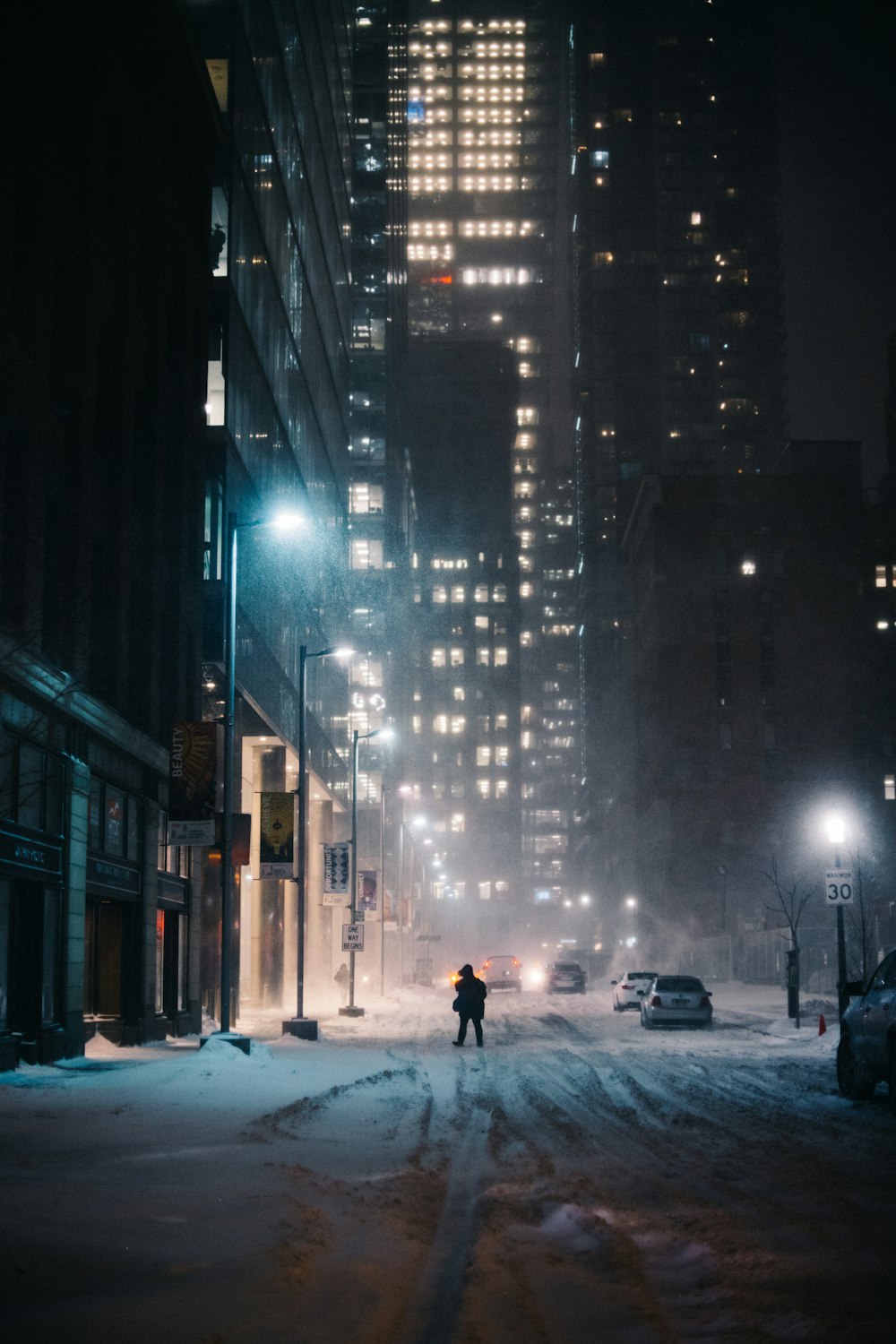 a person standing on a snowy street at night