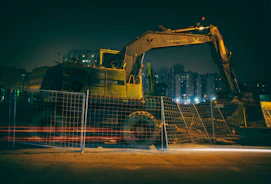 a large construction vehicle parked in front of a fence