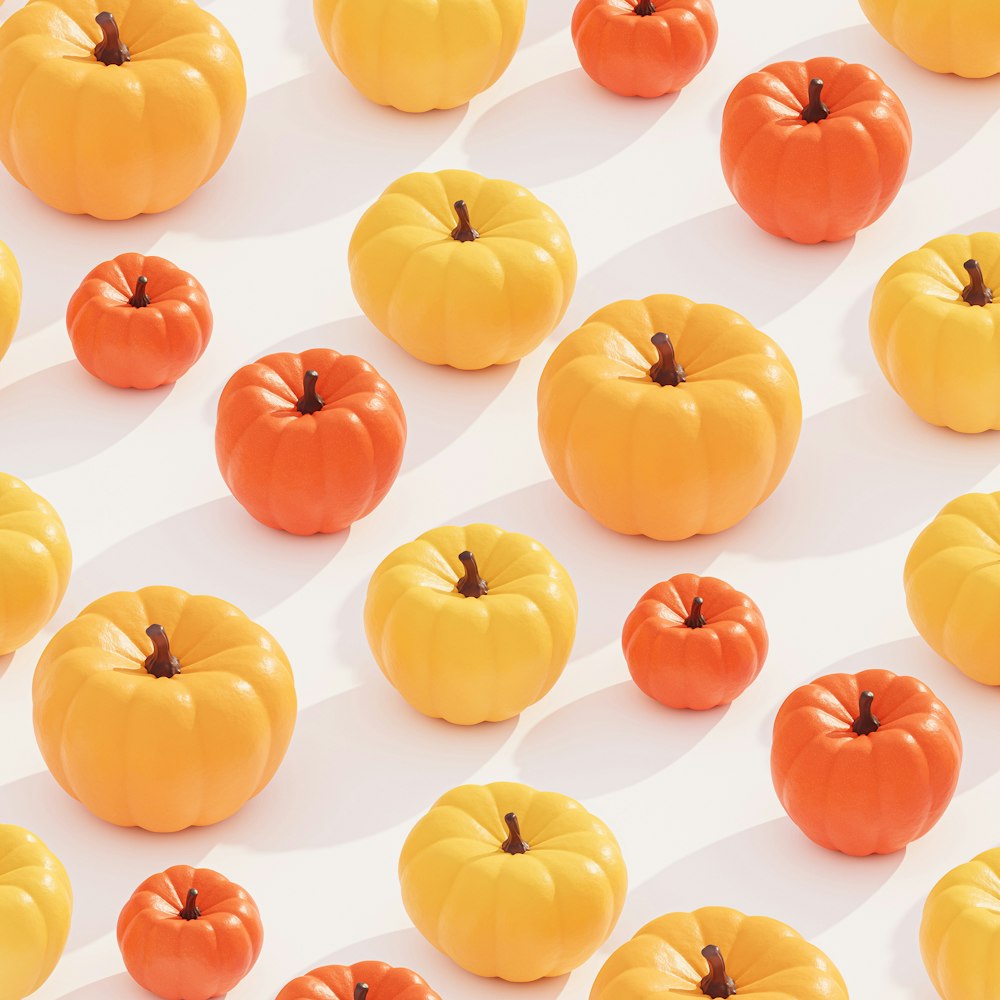 a group of orange and yellow pumpkins on a white surface