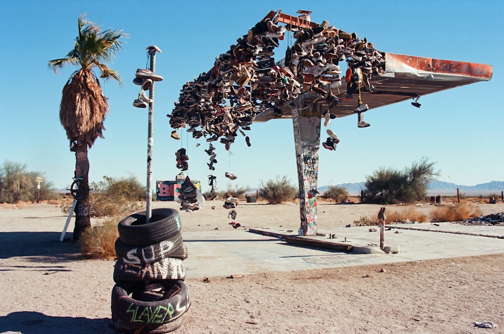 a bunch of shoes hanging from a pole in the desert