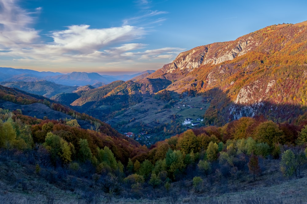 a scenic view of a valley with mountains in the background