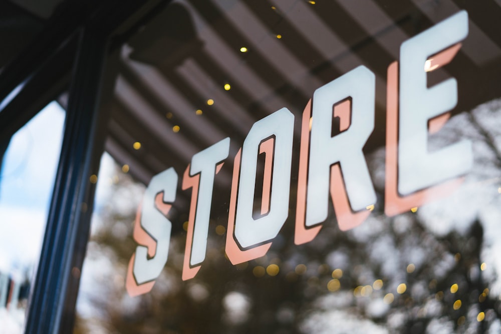 a close up of a store window with a tree in the background