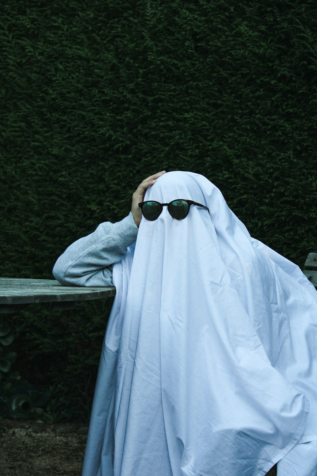 a person with sunglasses covering their face with a blanket