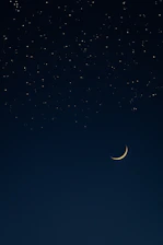 A serene night sky with a glowing golden crescent moon and twinkling stars.