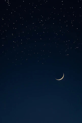 A serene night sky with a glowing golden crescent moon and twinkling stars.