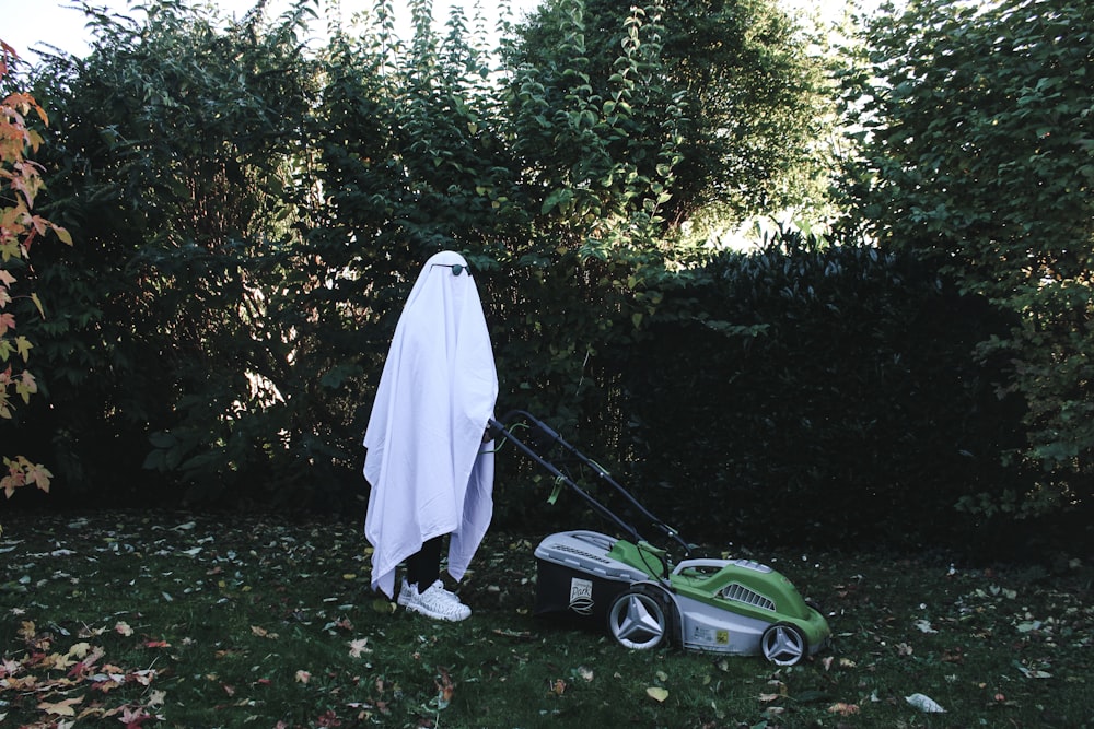 a green and white lawn mower sitting next to a white towel