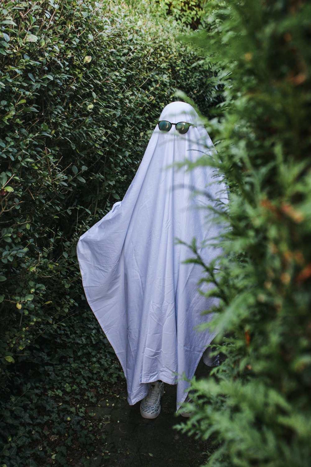 a person wearing a white cloak and sunglasses