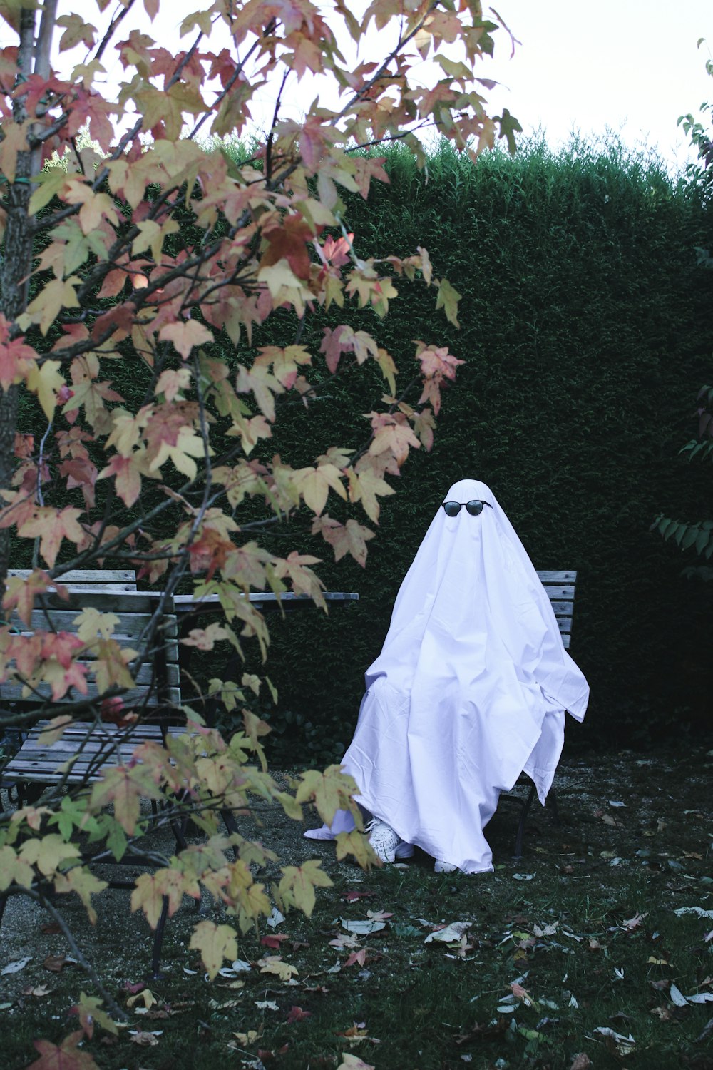 a white ghost sitting on top of a lush green field