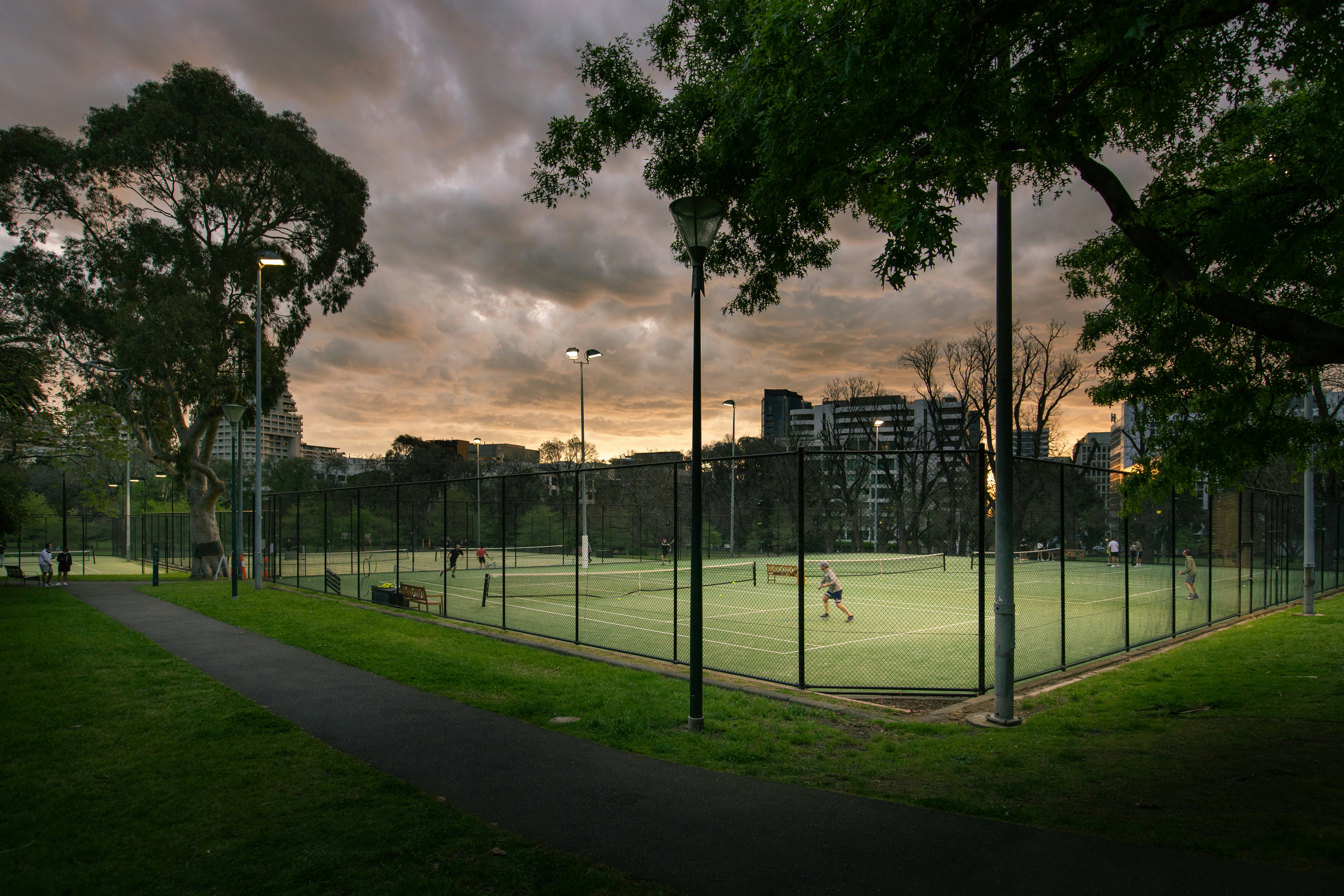 a tennis court surrounded by trees and grass