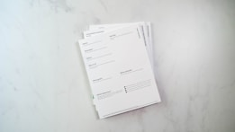 a stack of papers sitting on top of a white counter