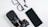 A flat lay of technology items including a camera with a large lens, eyeglasses, wireless earbuds, and a smartphone placed on a white surface.