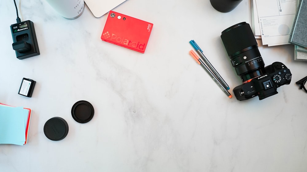 a table with a camera, notebooks, and other items on it