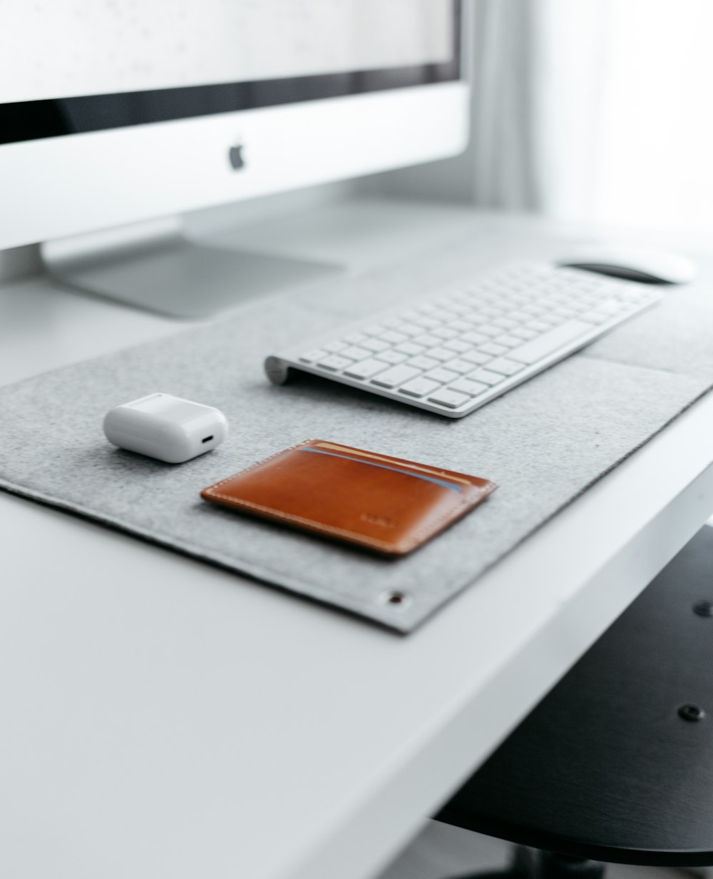 a desk with a keyboard, mouse, and a wallet on it