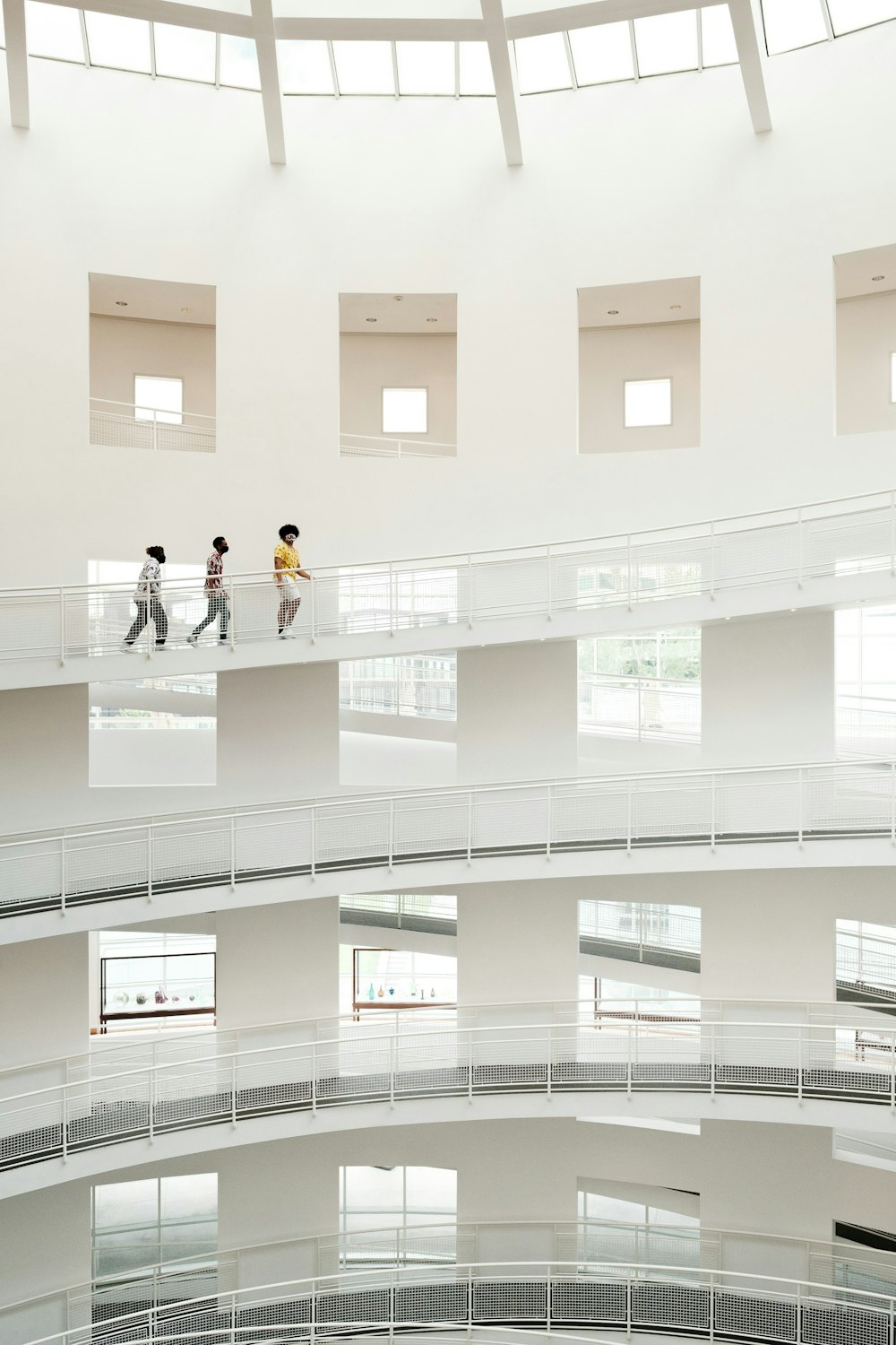 a group of people walking across a white building