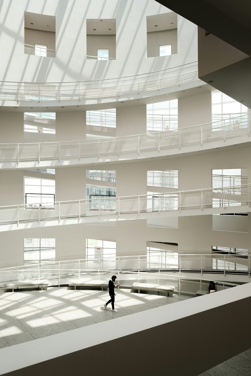 a person walking in a large building with lots of windows