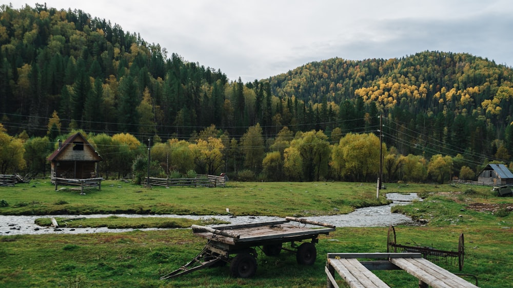 a grassy field with a wooden table and a mountain in the background