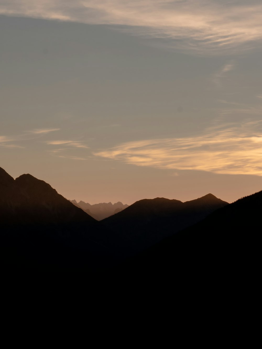 the silhouette of a mountain range at sunset