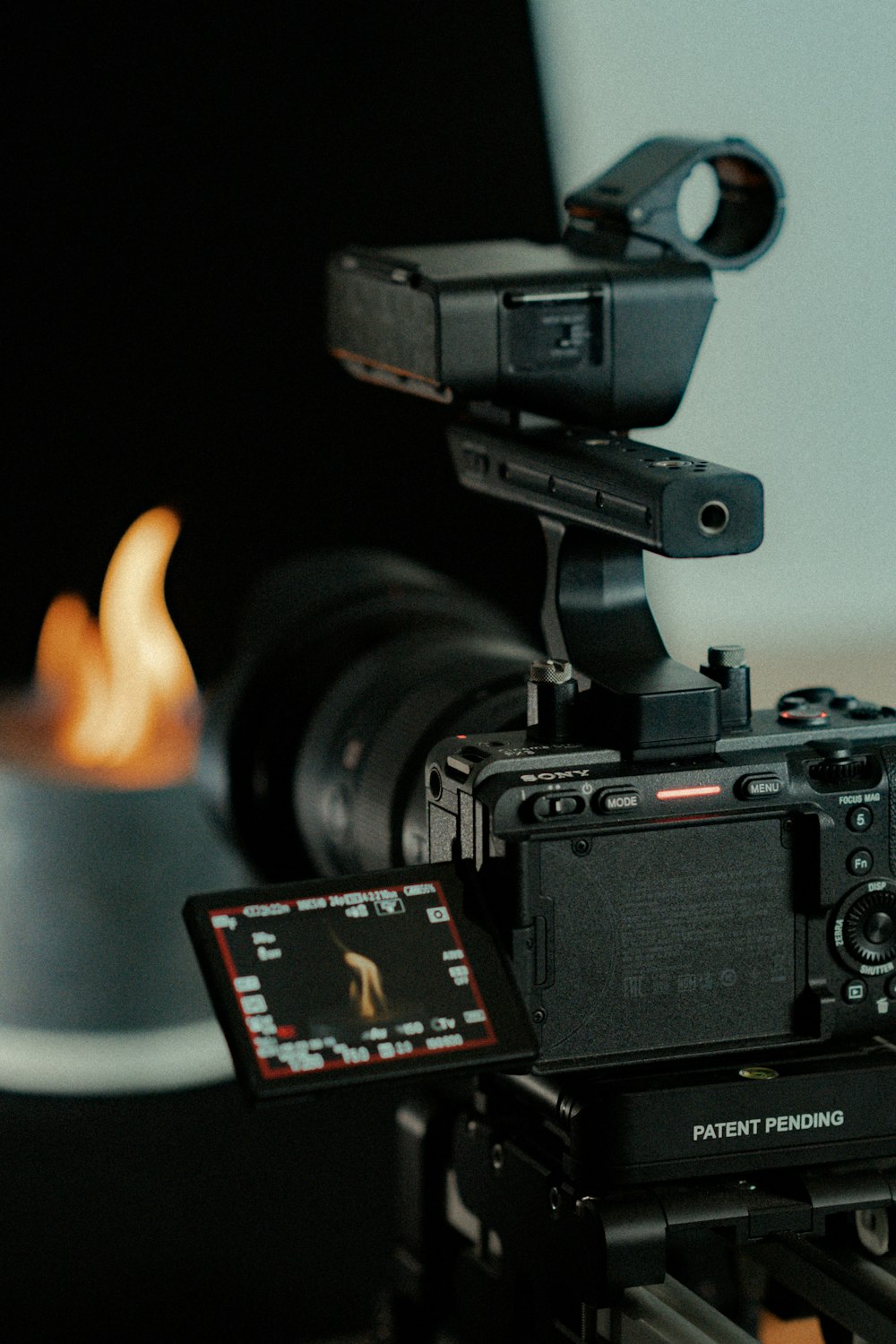 a video camera with a flame in the background