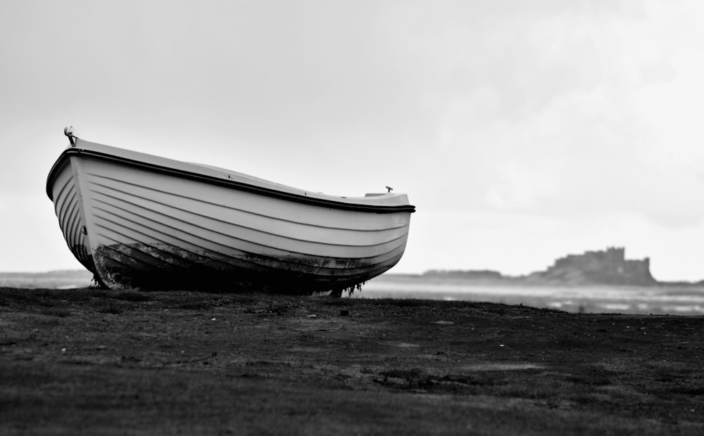 a black and white photo of a boat on the beach